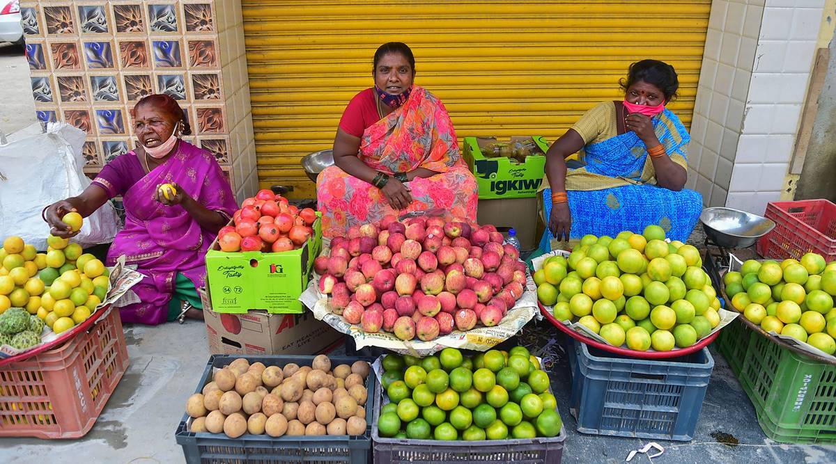 Roadside vendors selling fruits wait for customers, as coronavirus cases surge across the country, in Bengaluru. (PTI)